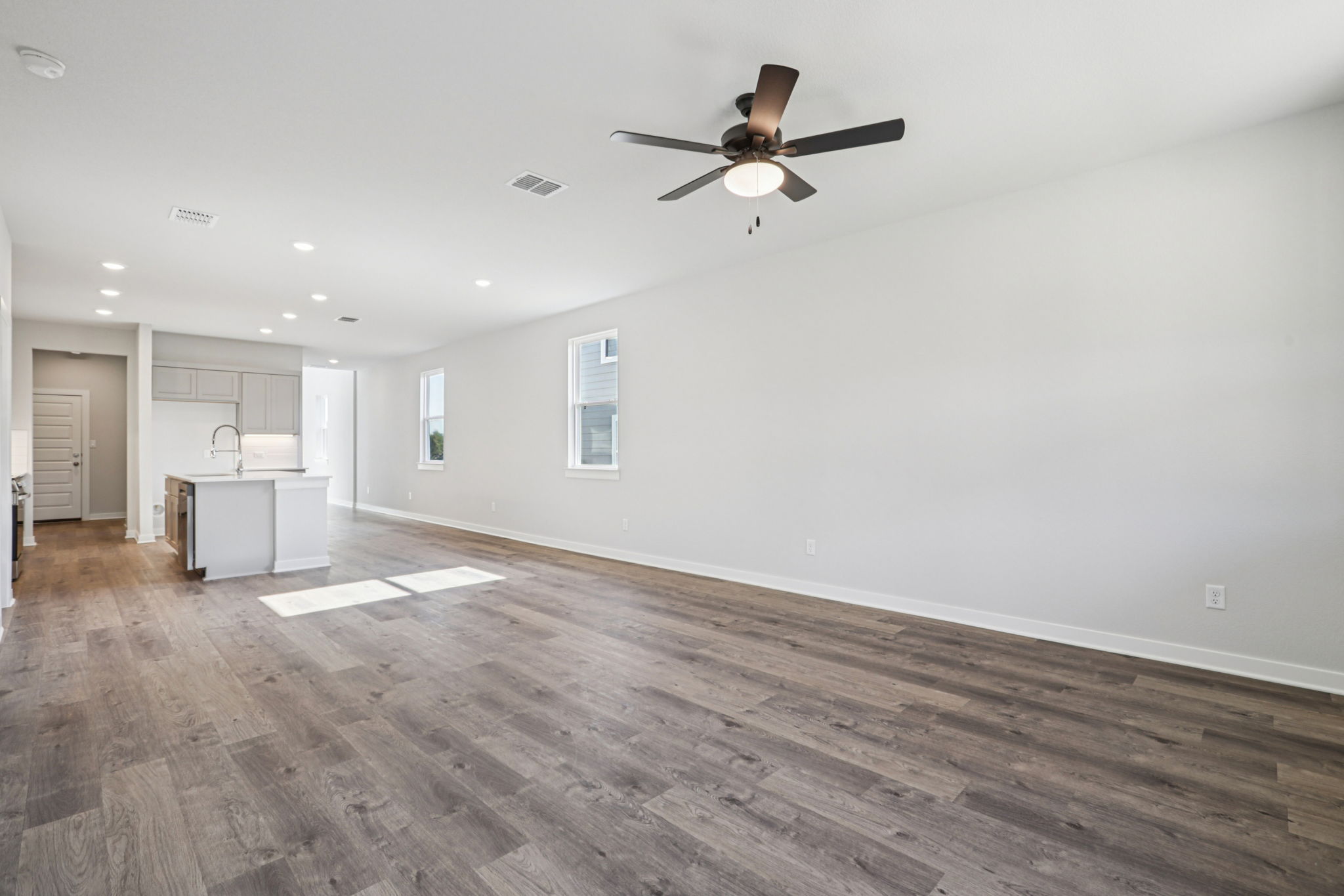 A room with a wood floor and a ceiling fan.