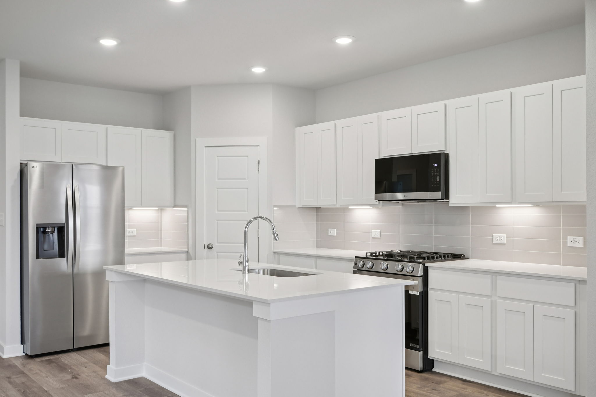 A kitchen with white cabinets.