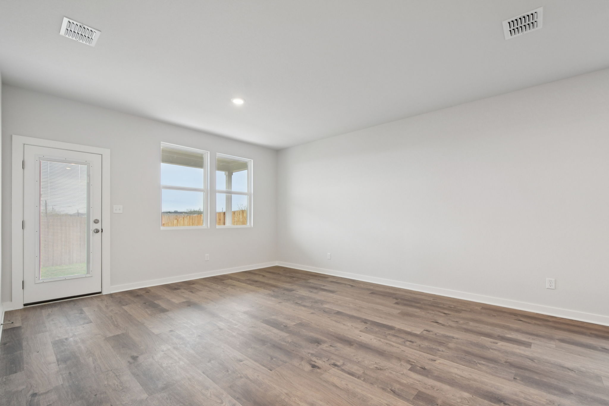 A room with a wood floor and a wood floor with a door.