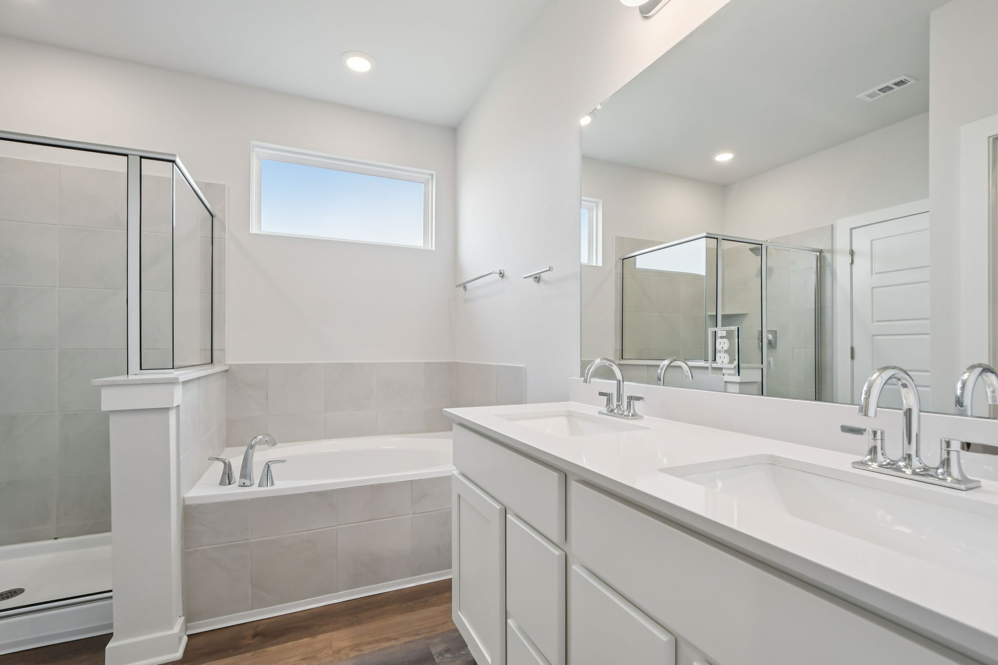 A bathroom with a tub sink and mirror.
