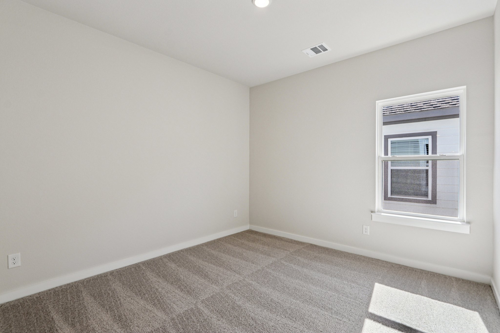 A room with a carpet and a window.