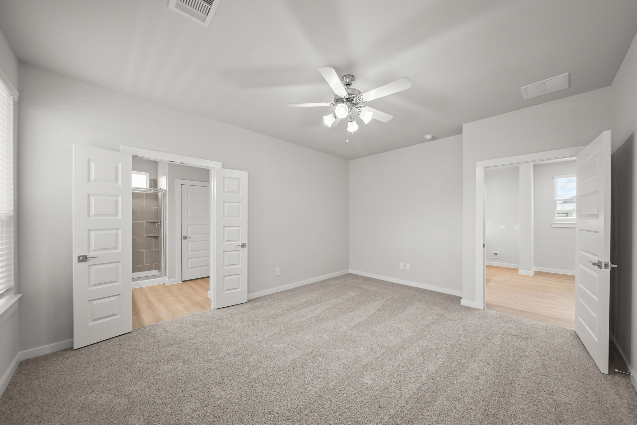 A room with white cabinets and a ceiling fan.