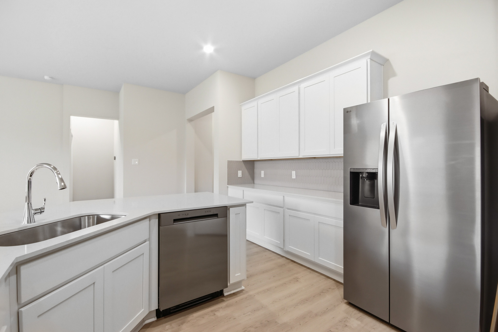 A kitchen with white cabinets.