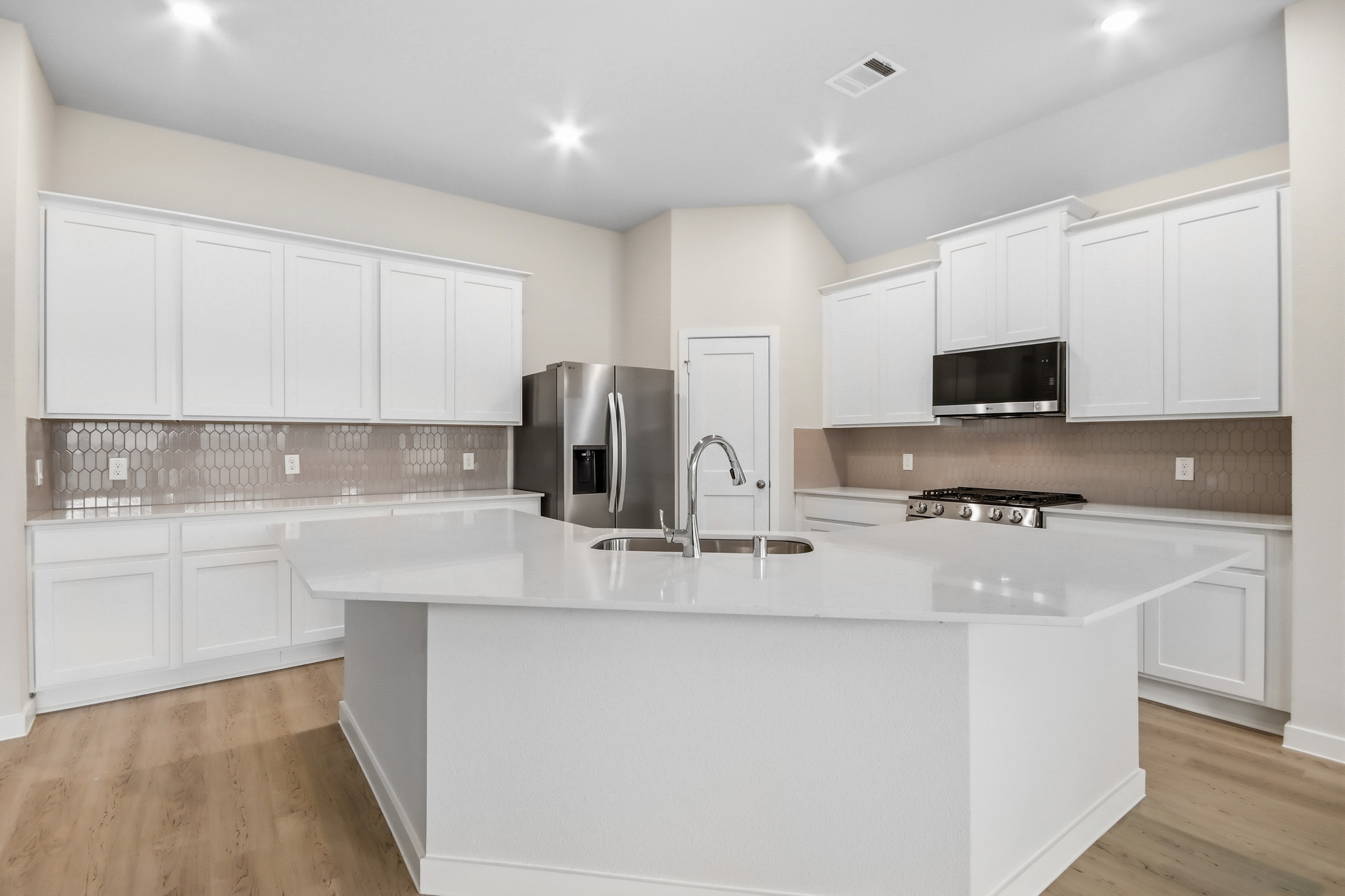 A kitchen with white cabinets.