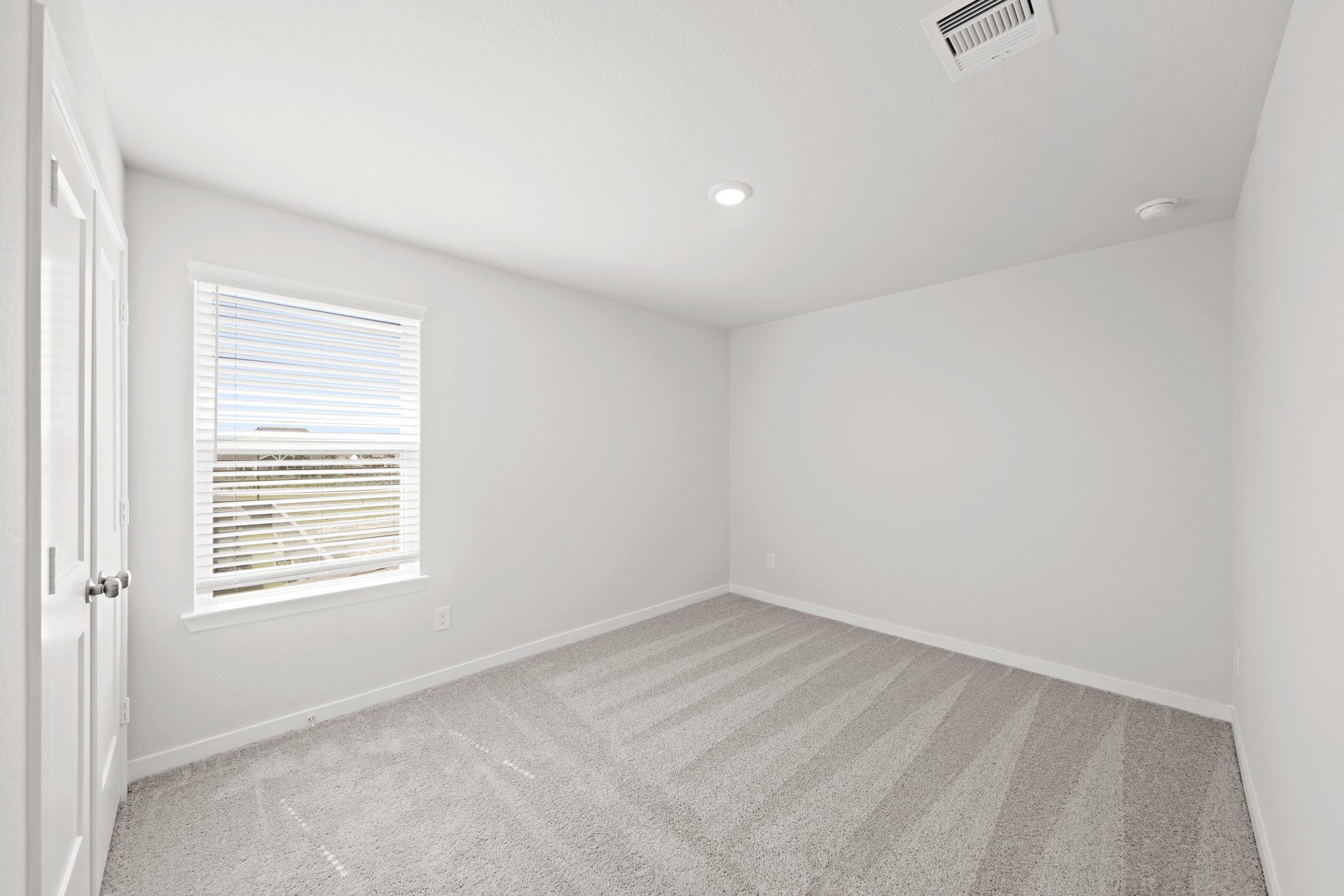 A room with a carpet and a window.