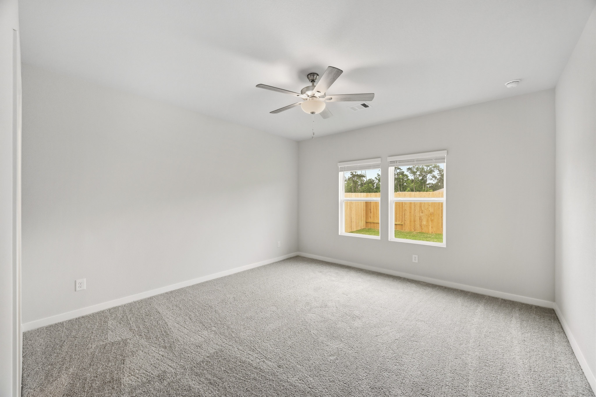 A room with a ceiling fan and a window.