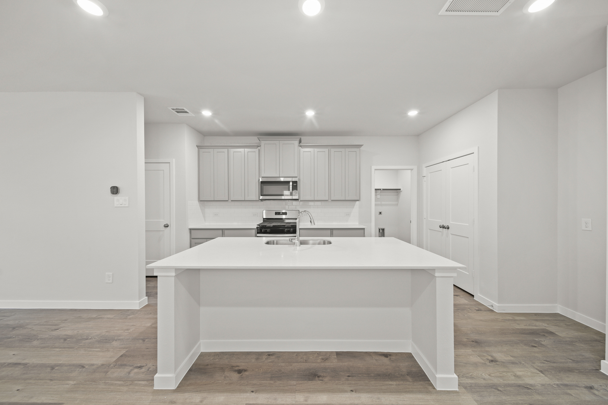 A large white kitchen with white cabinets.