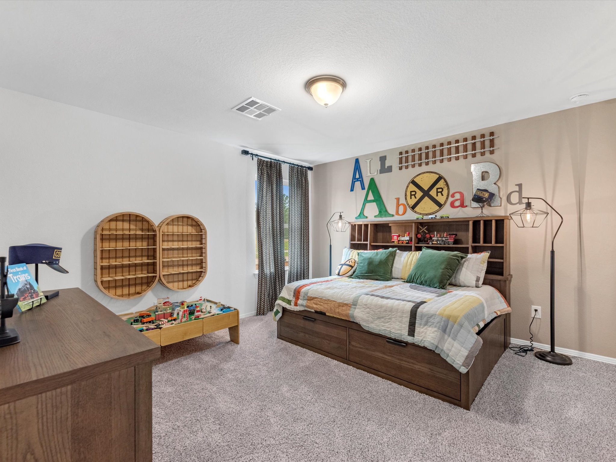 A bedroom with a bed and desk.