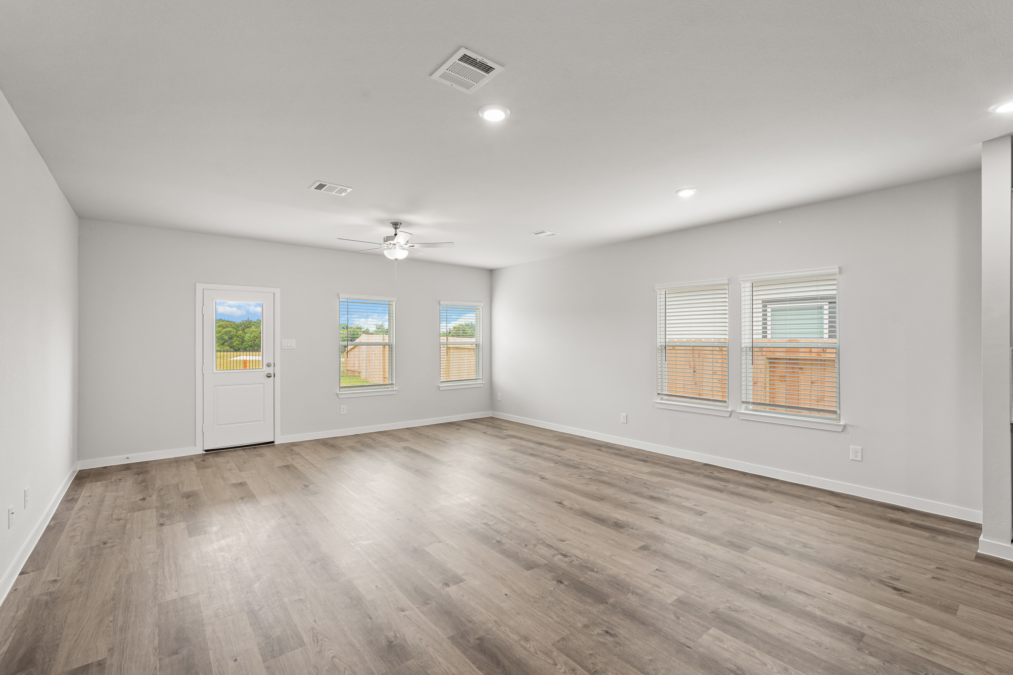 A room with a wood floor and a wood floor with a light on the ceiling.
