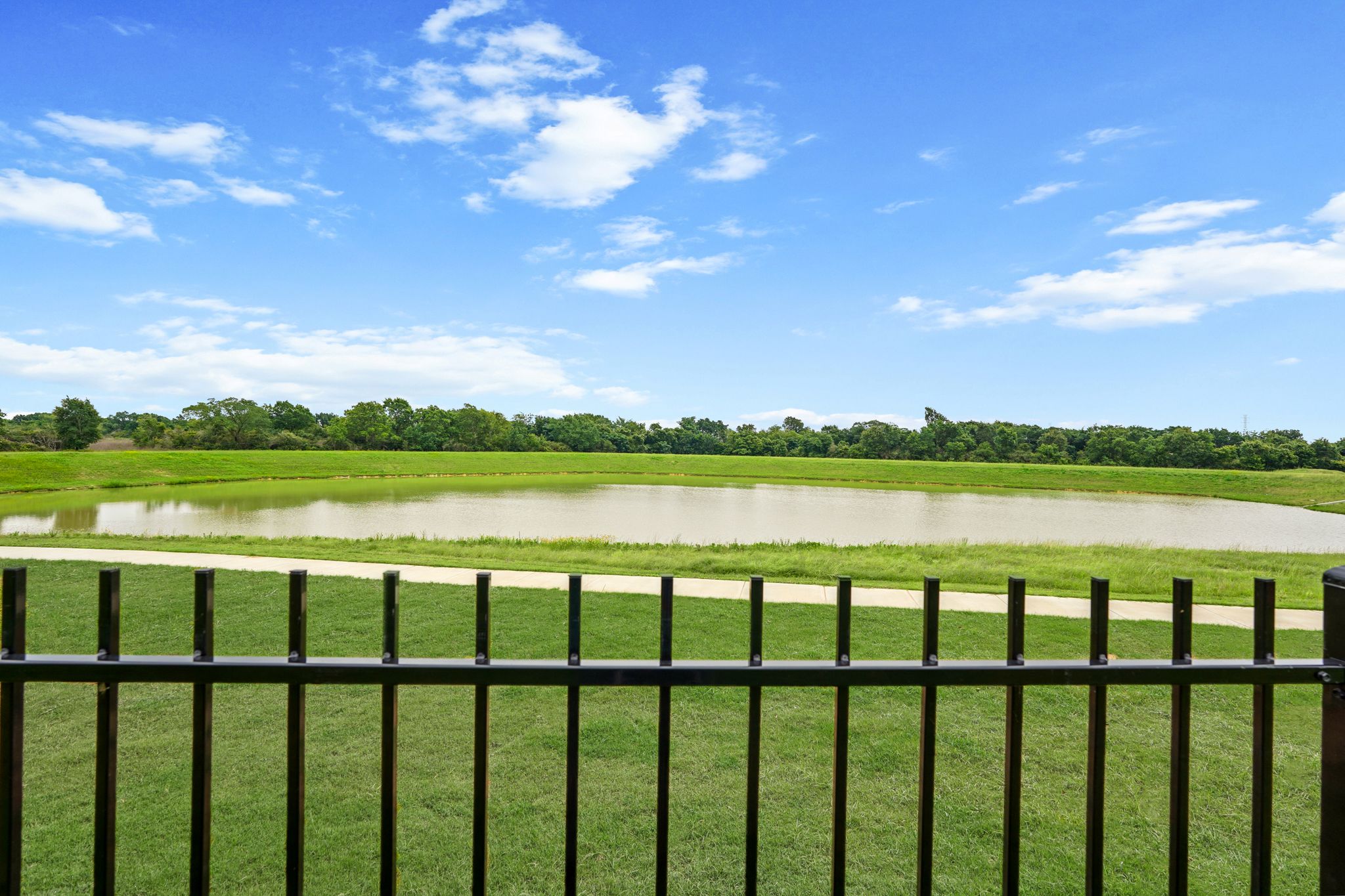 A field with a fence and a river in the distance.