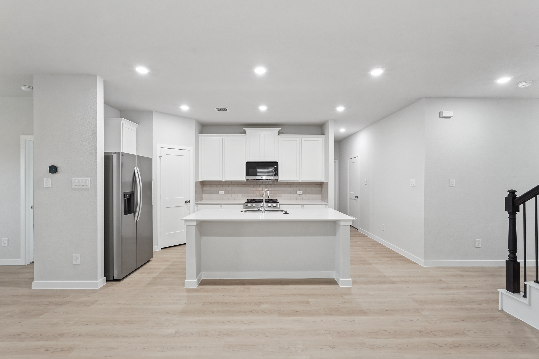 A kitchen with white cabinets.
