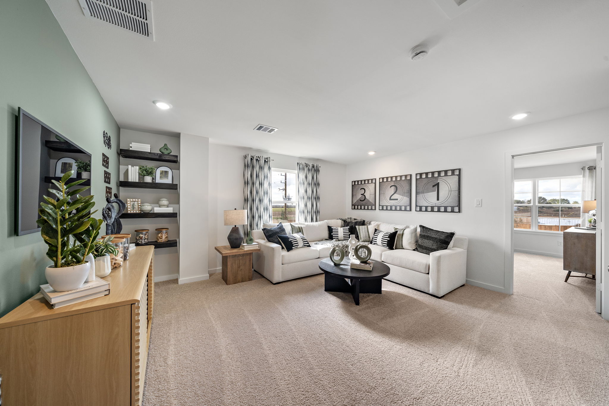A living room with a white couch and a tv.