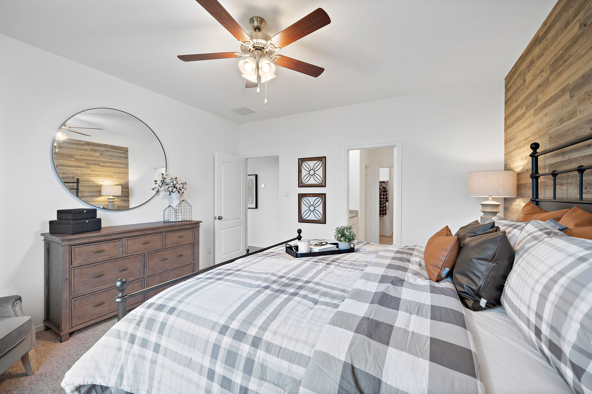A bedroom with a large mirror.