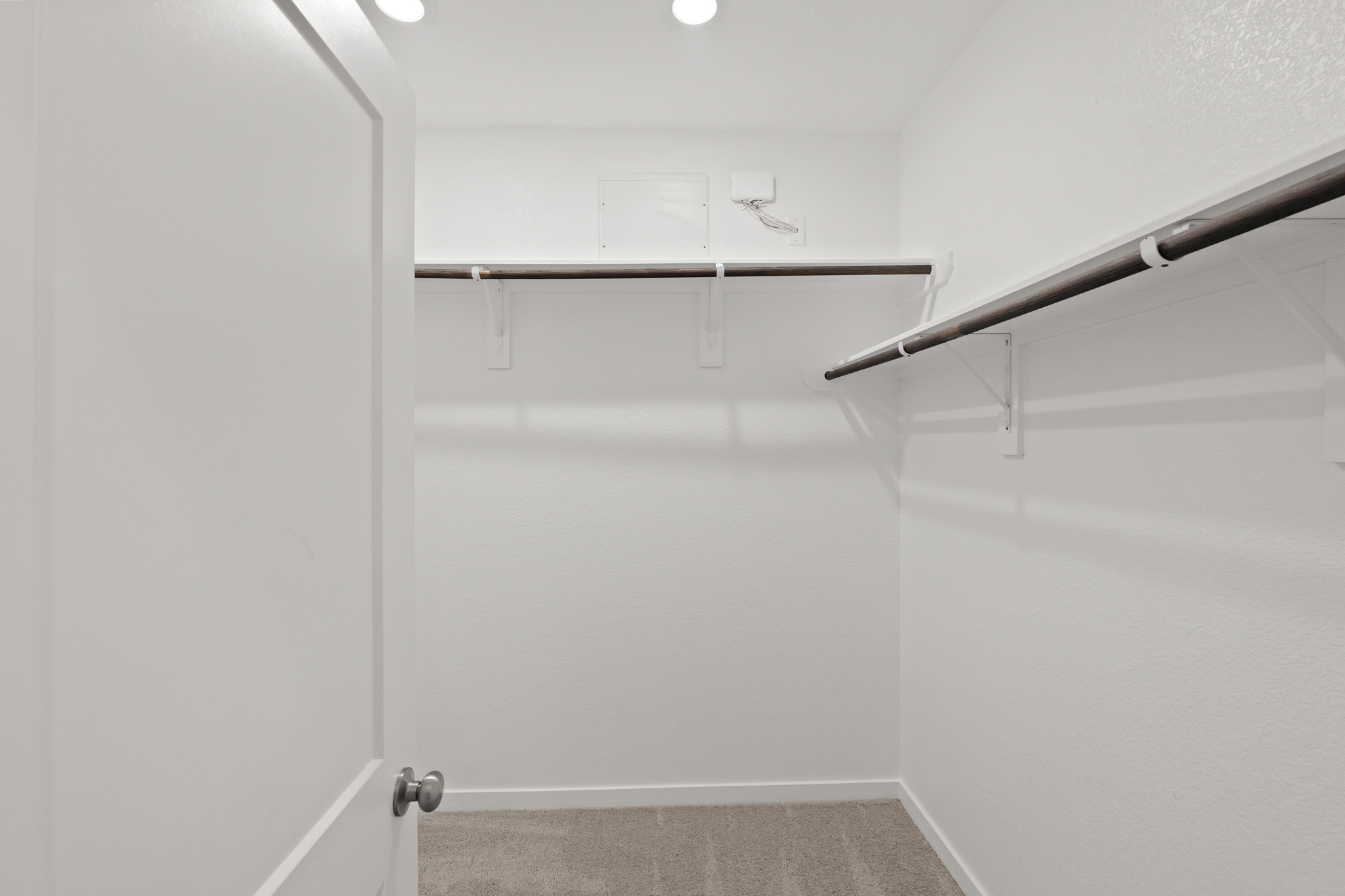 A white wall with a metal bar.