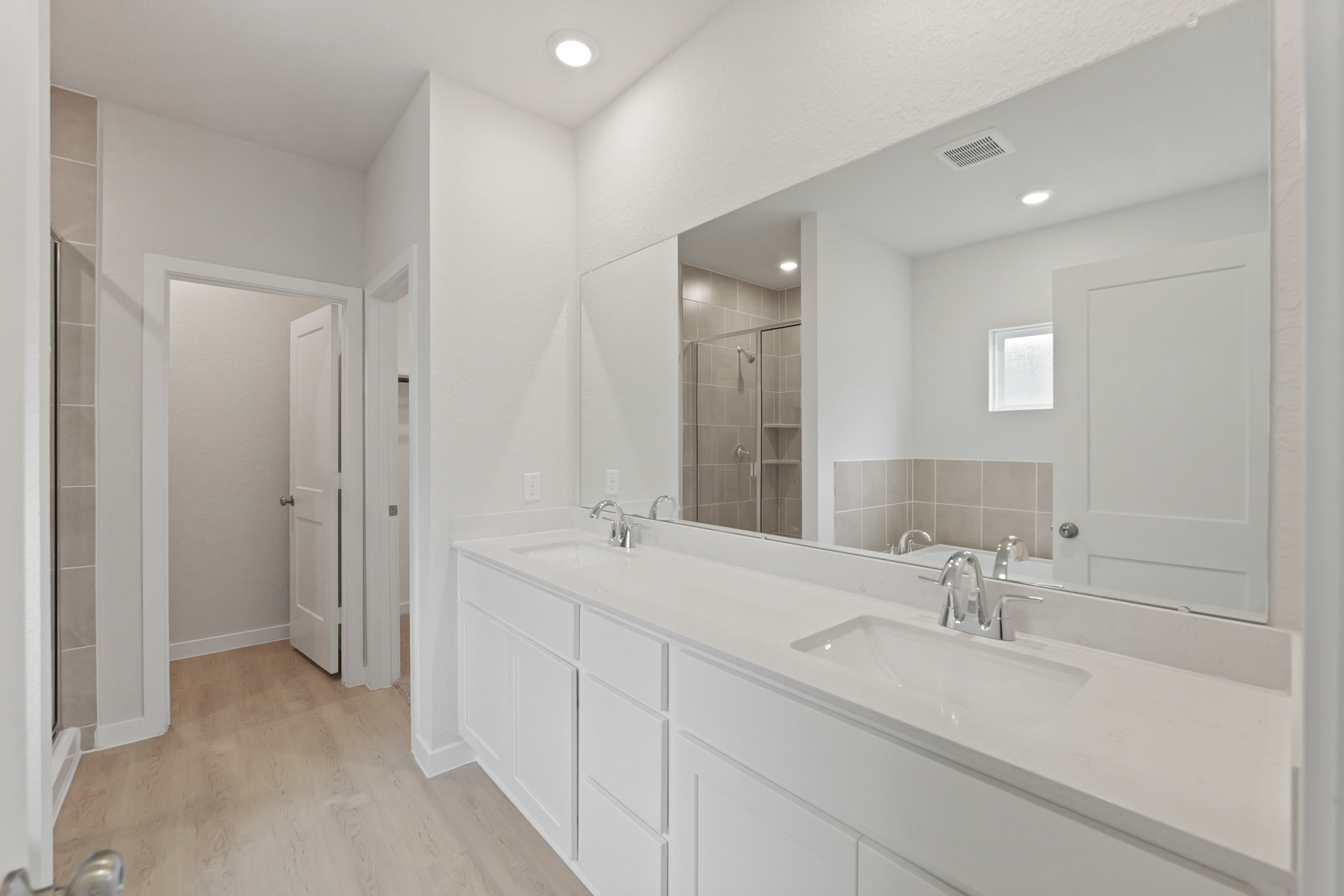 A bathroom with white cabinets.