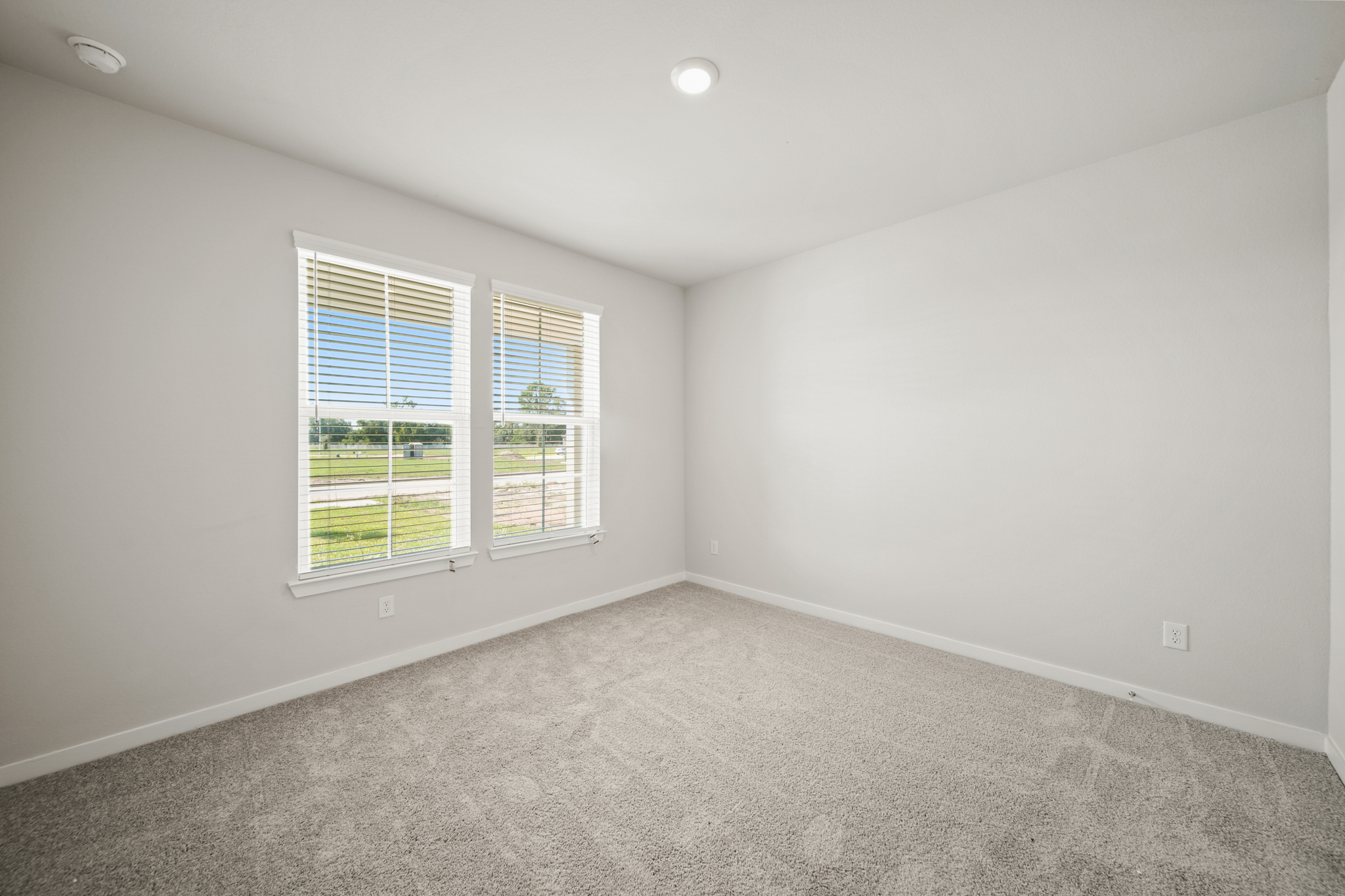 A room with a window and a carpet.