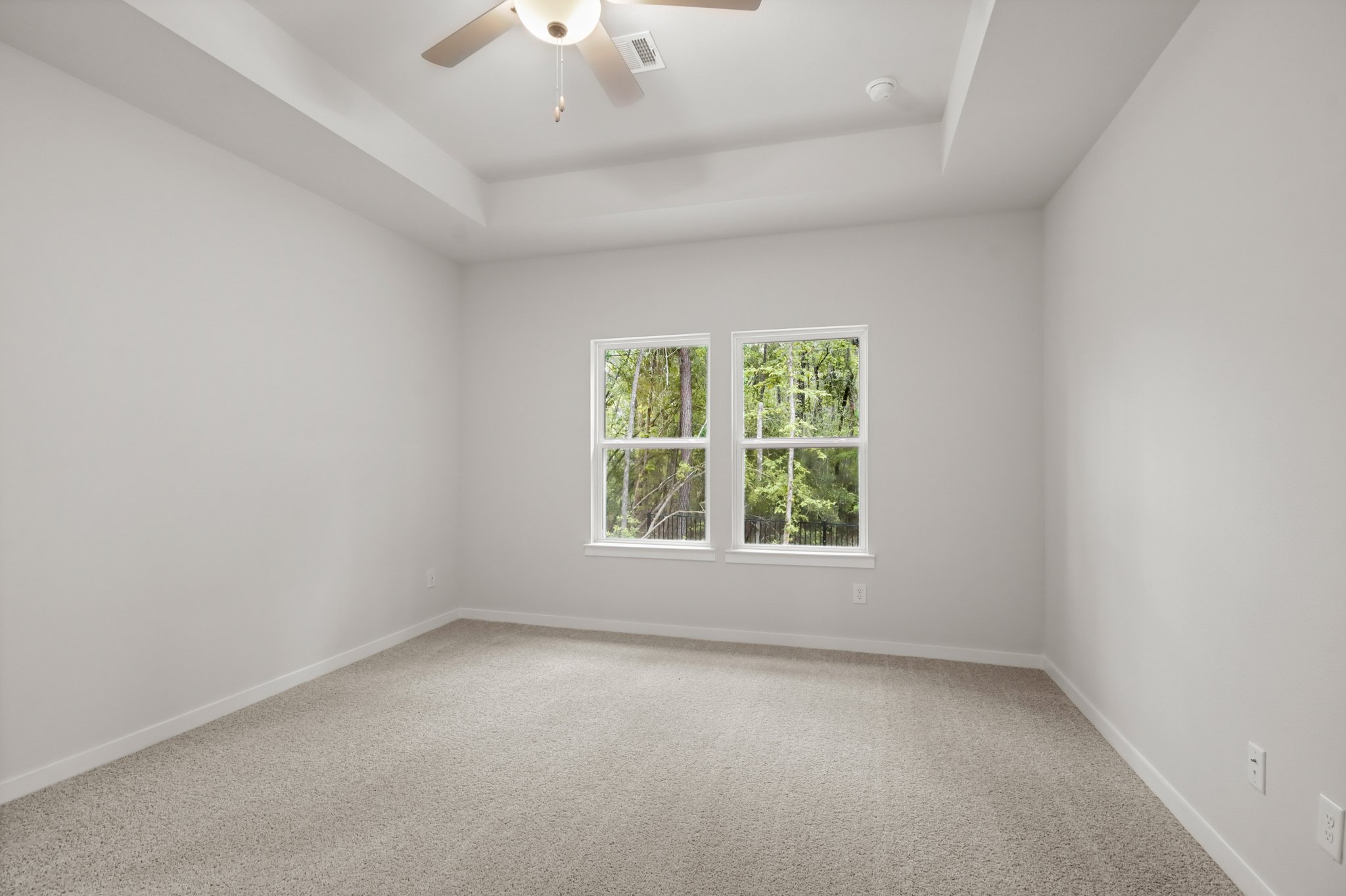 A room with a ceiling fan and a window.