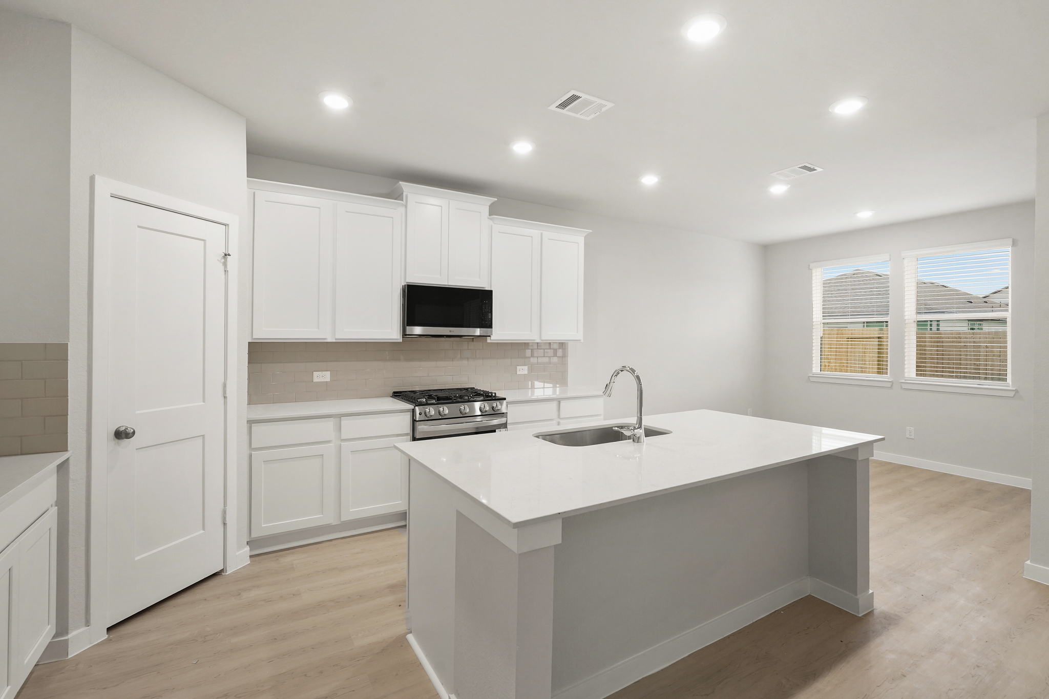 A kitchen with white cabinets.