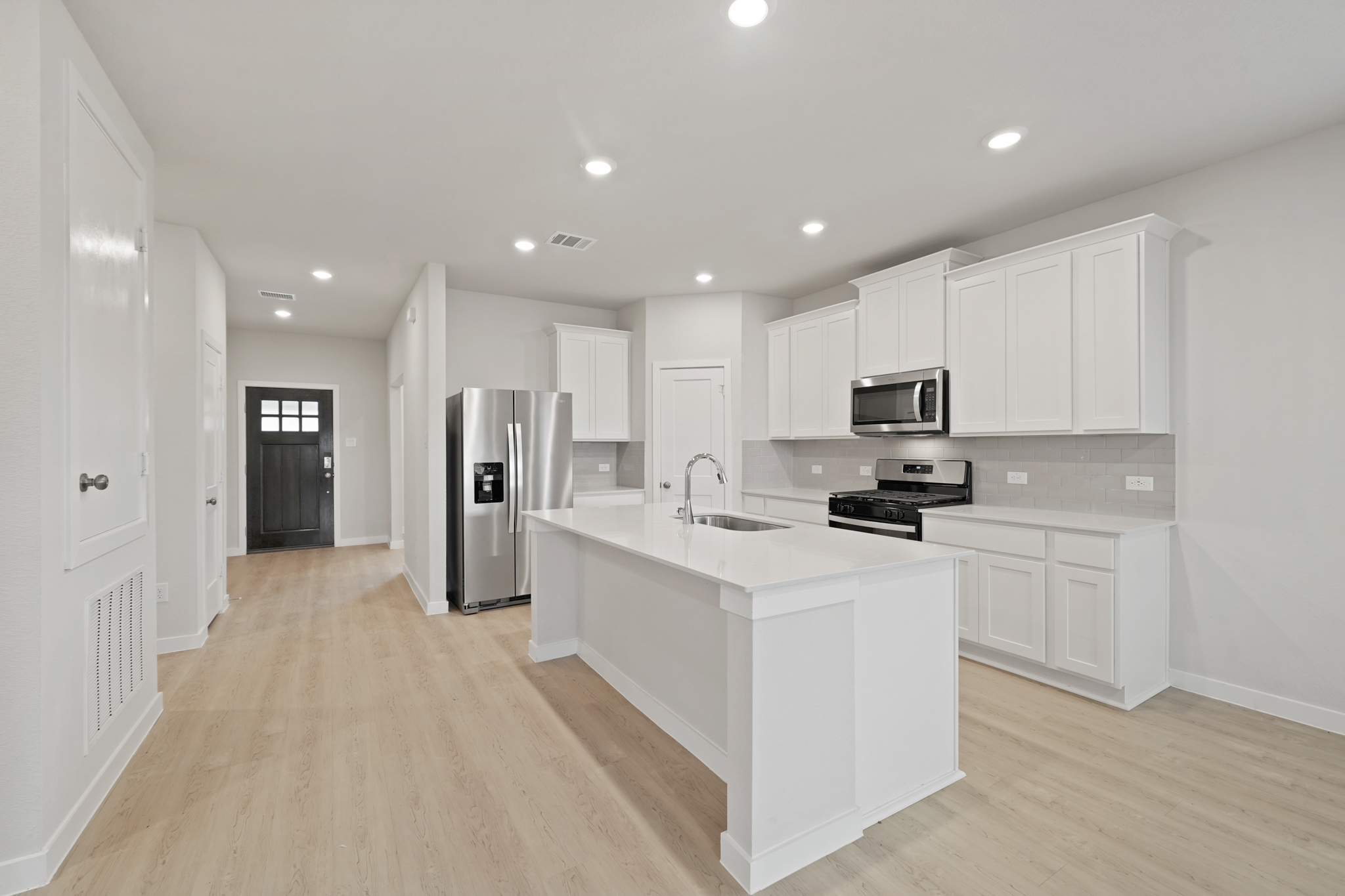 A kitchen with white cabinets.