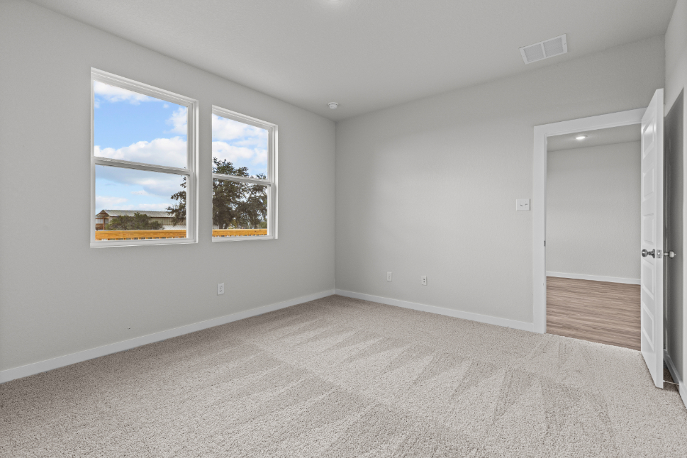 A room with a window and a door with a view of the ocean.