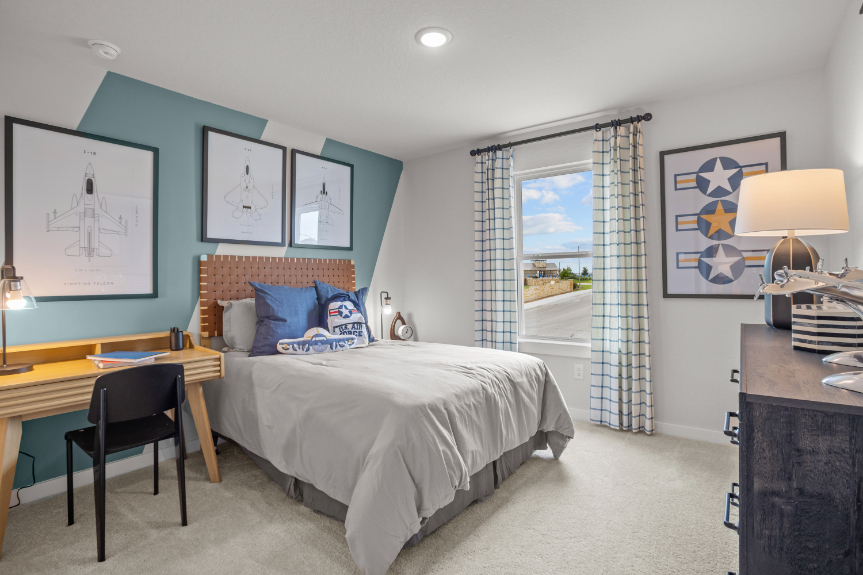 A bedroom with a bed desk and a window.