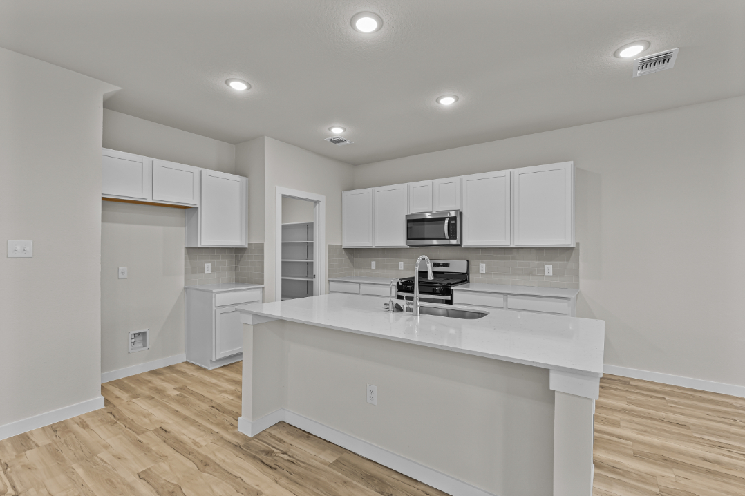 A kitchen with white cabinets.