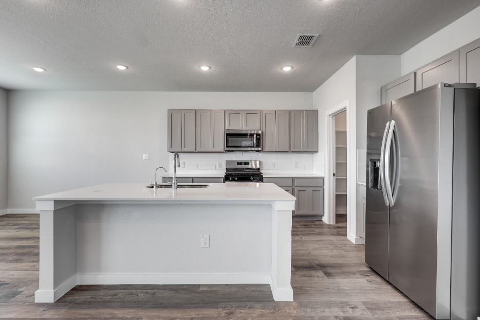 A kitchen with white cabinets.
