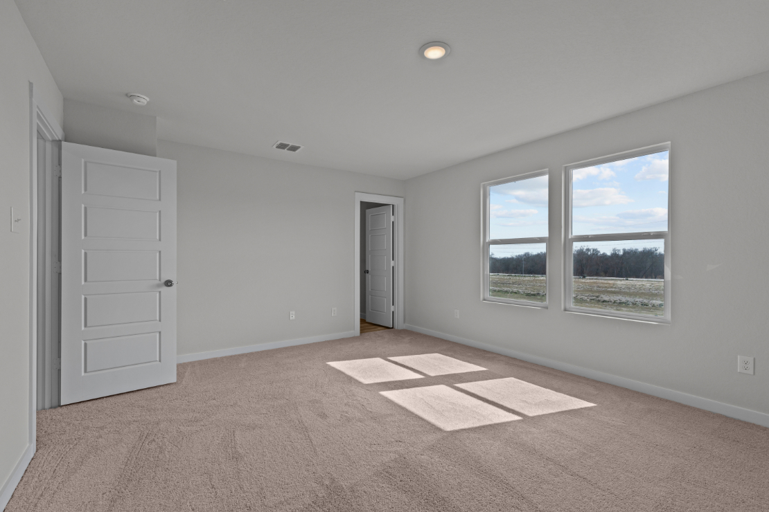 A room with a window and a rug in it.
