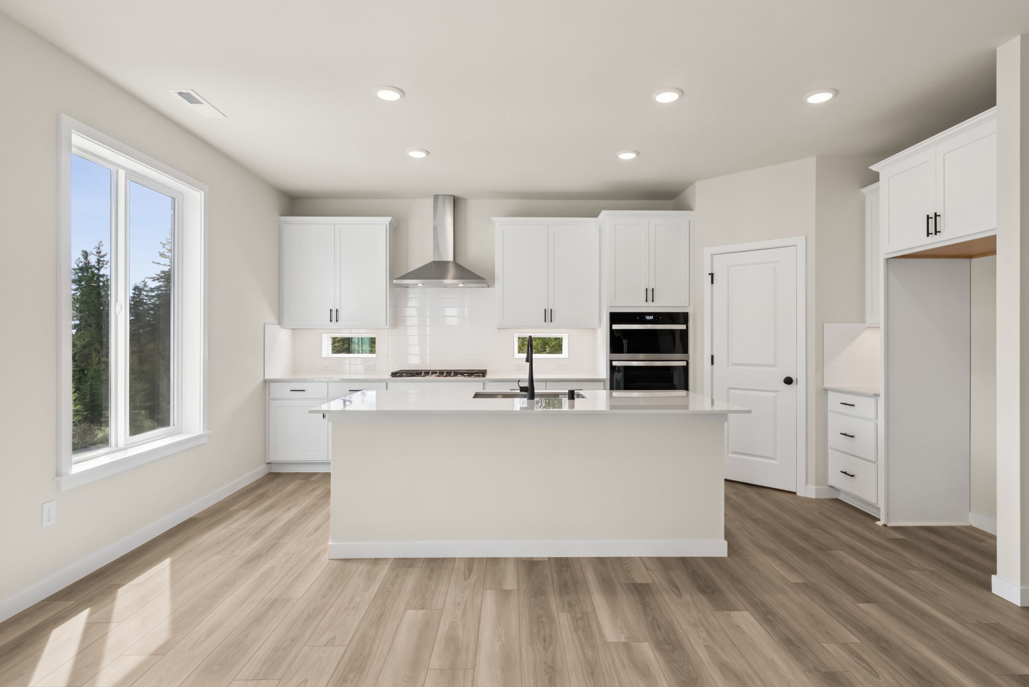 A kitchen with white cabinets.