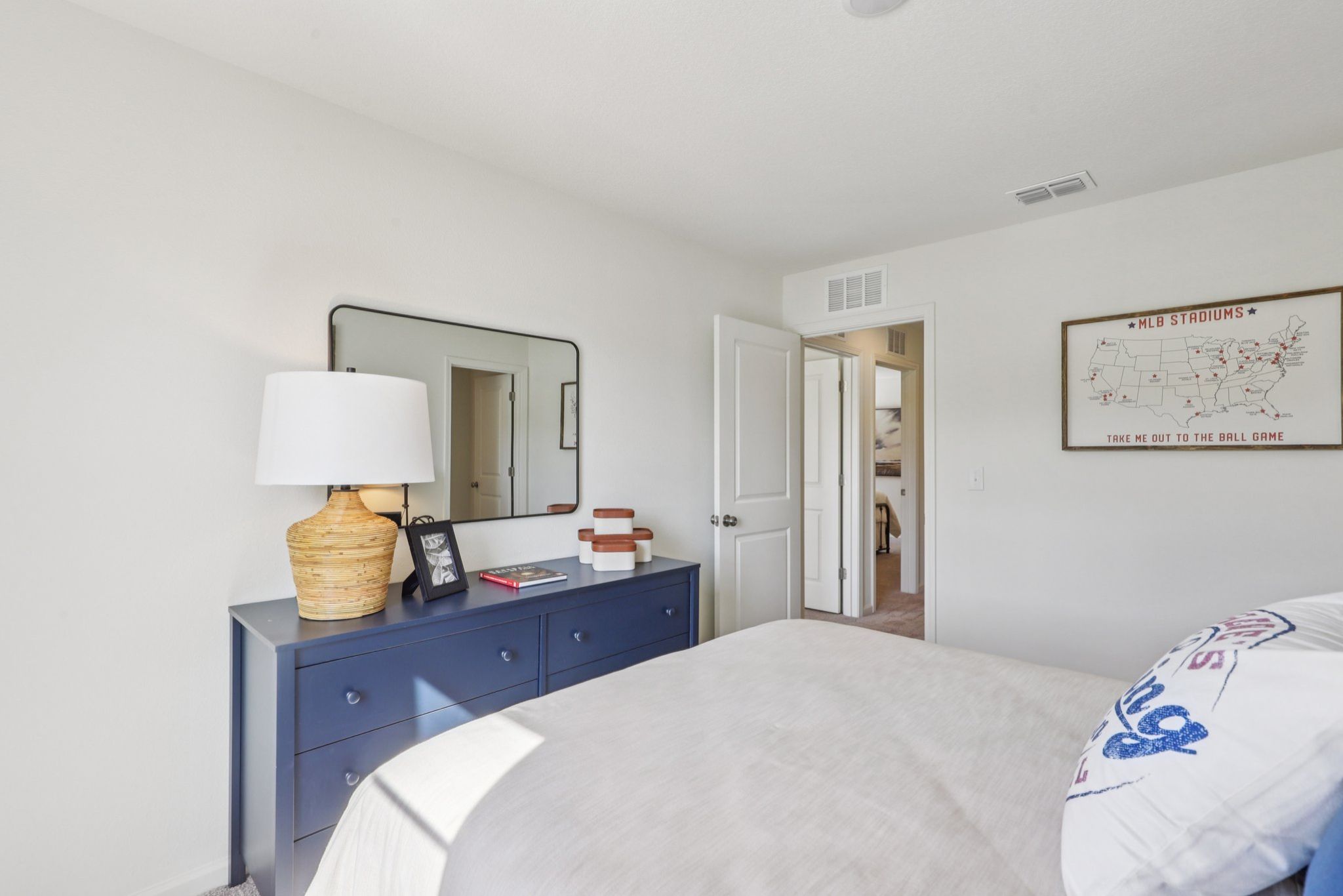 A bedroom with a bed and a mirror.