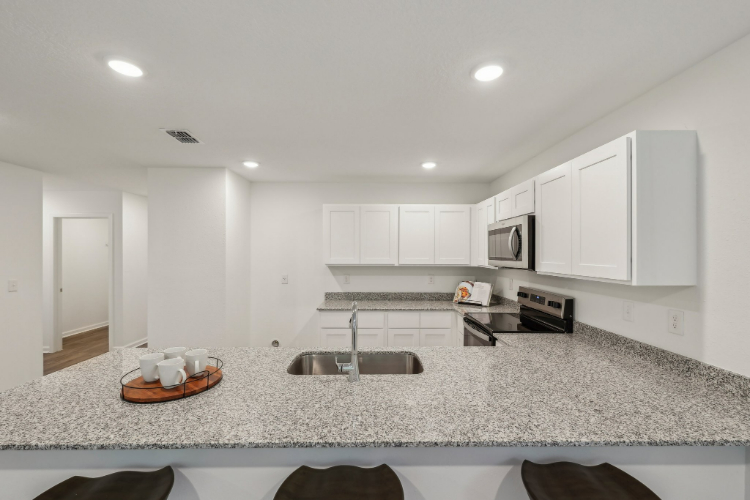 A kitchen with white cabinets.