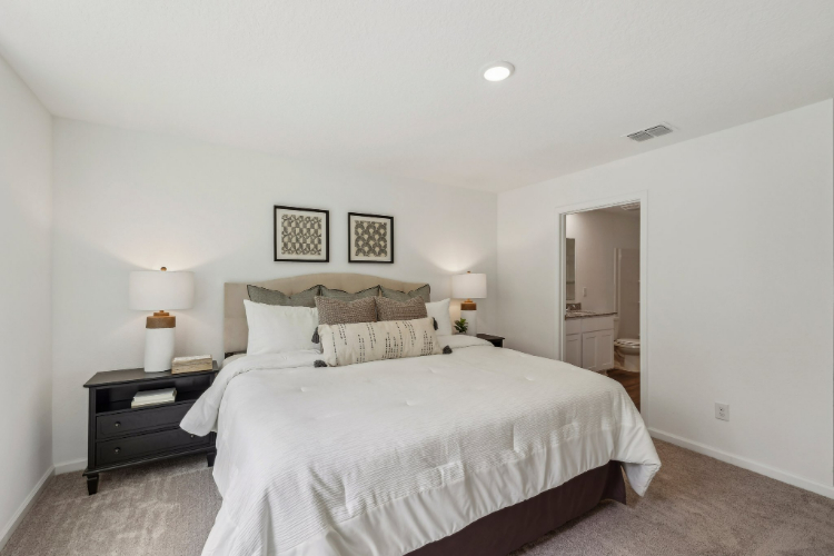 A bedroom with a bed and lamps.