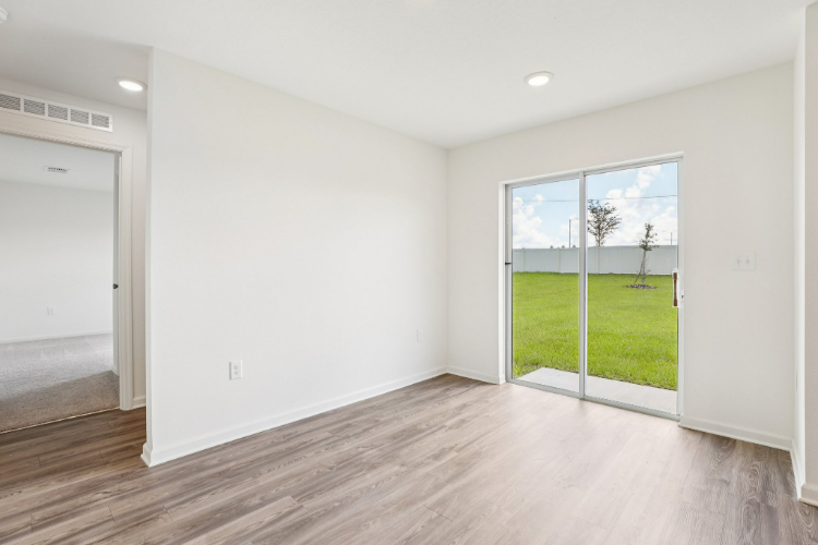 A room with a wood floor and a large window.