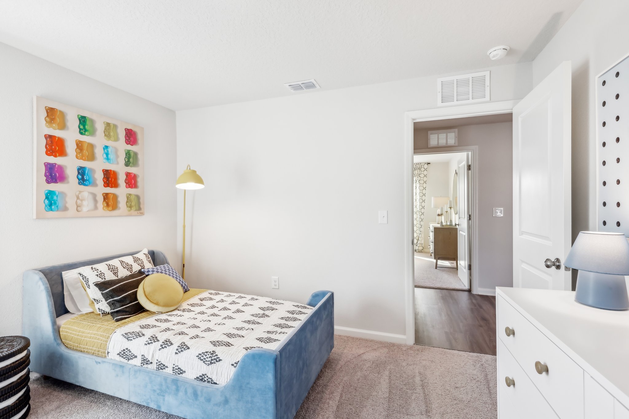 A bedroom with a bed and a lamp.