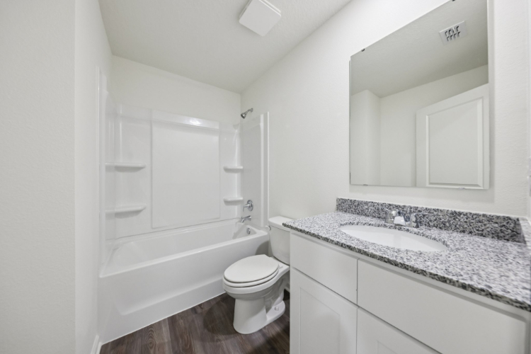 A bathroom with a tub sink and toilet.