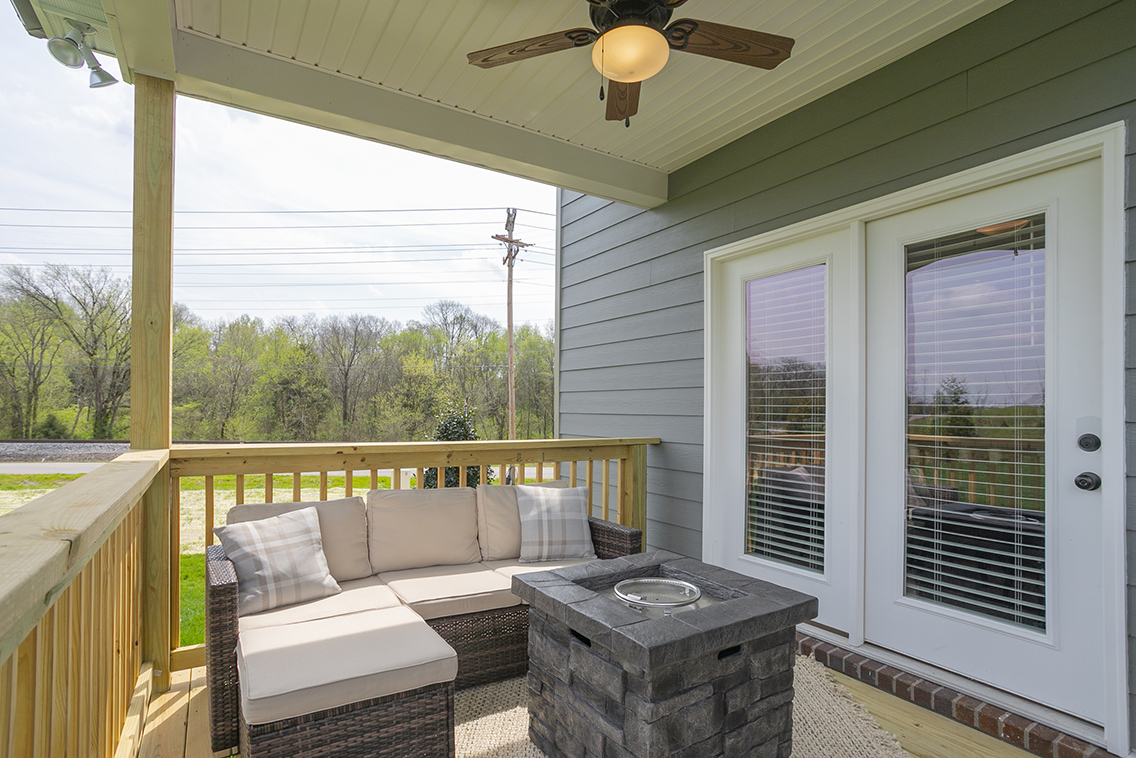 A porch with a wood railing and a wood railing with a wood railing.