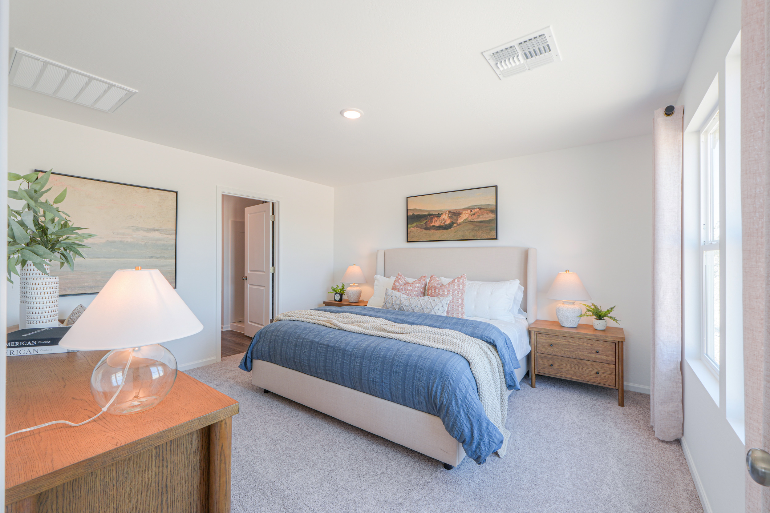 A bedroom with a bed and lamps.