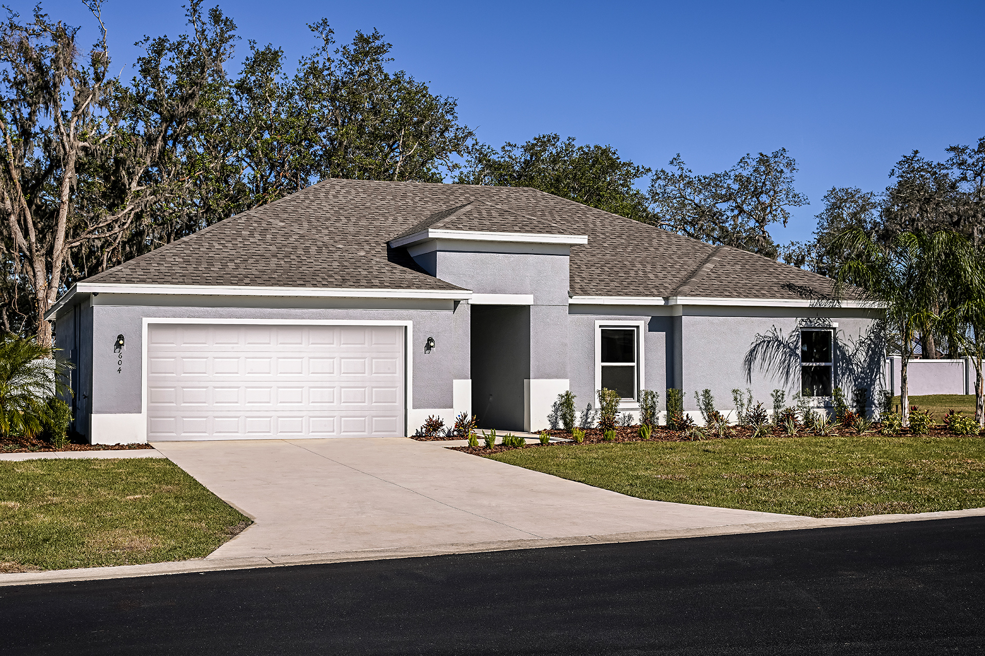 A house with a garage with Mission House in the background.