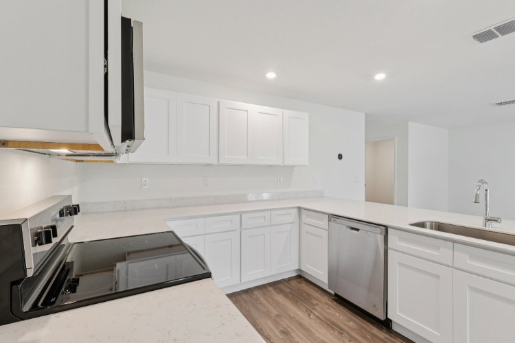 A kitchen with white cabinets.