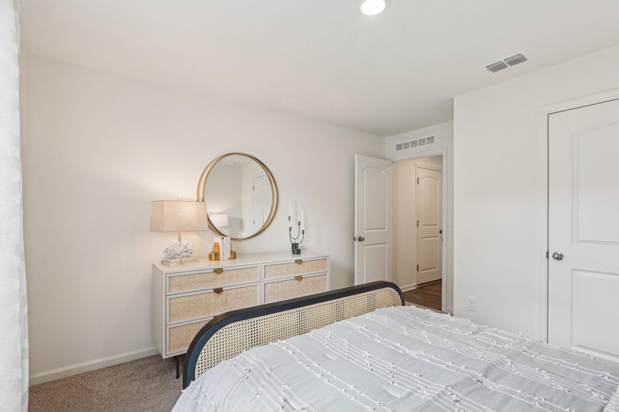 A bedroom with a mirror and a bed.