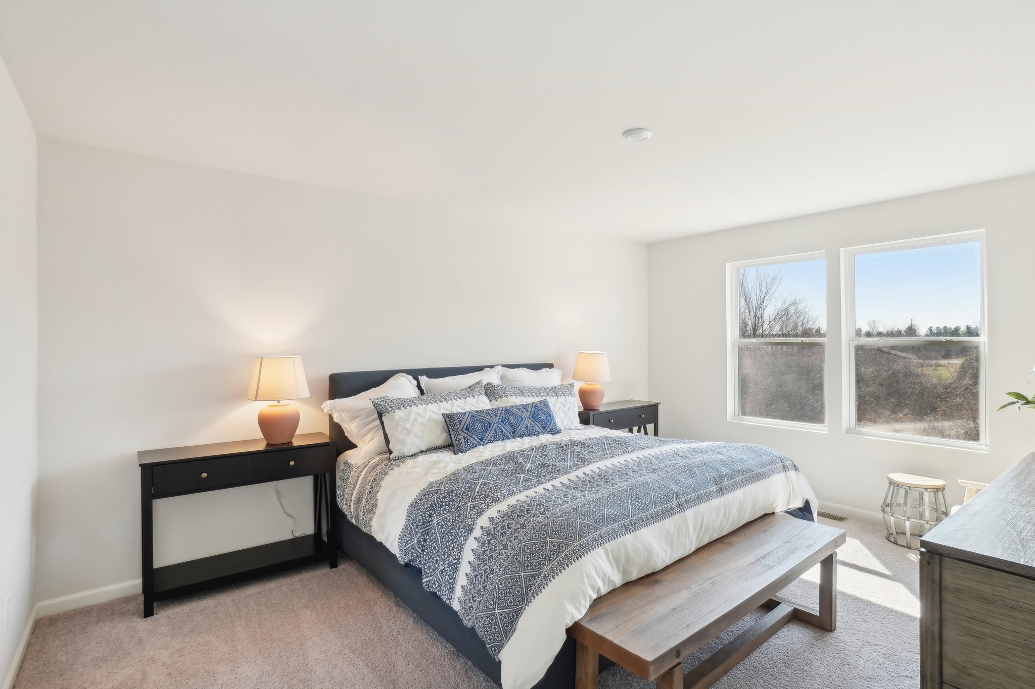 A bedroom with a bed and a bench.