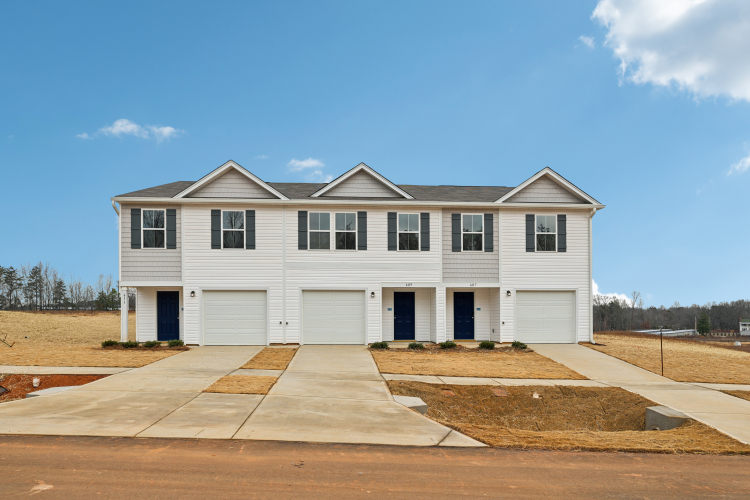 A white house with garages.