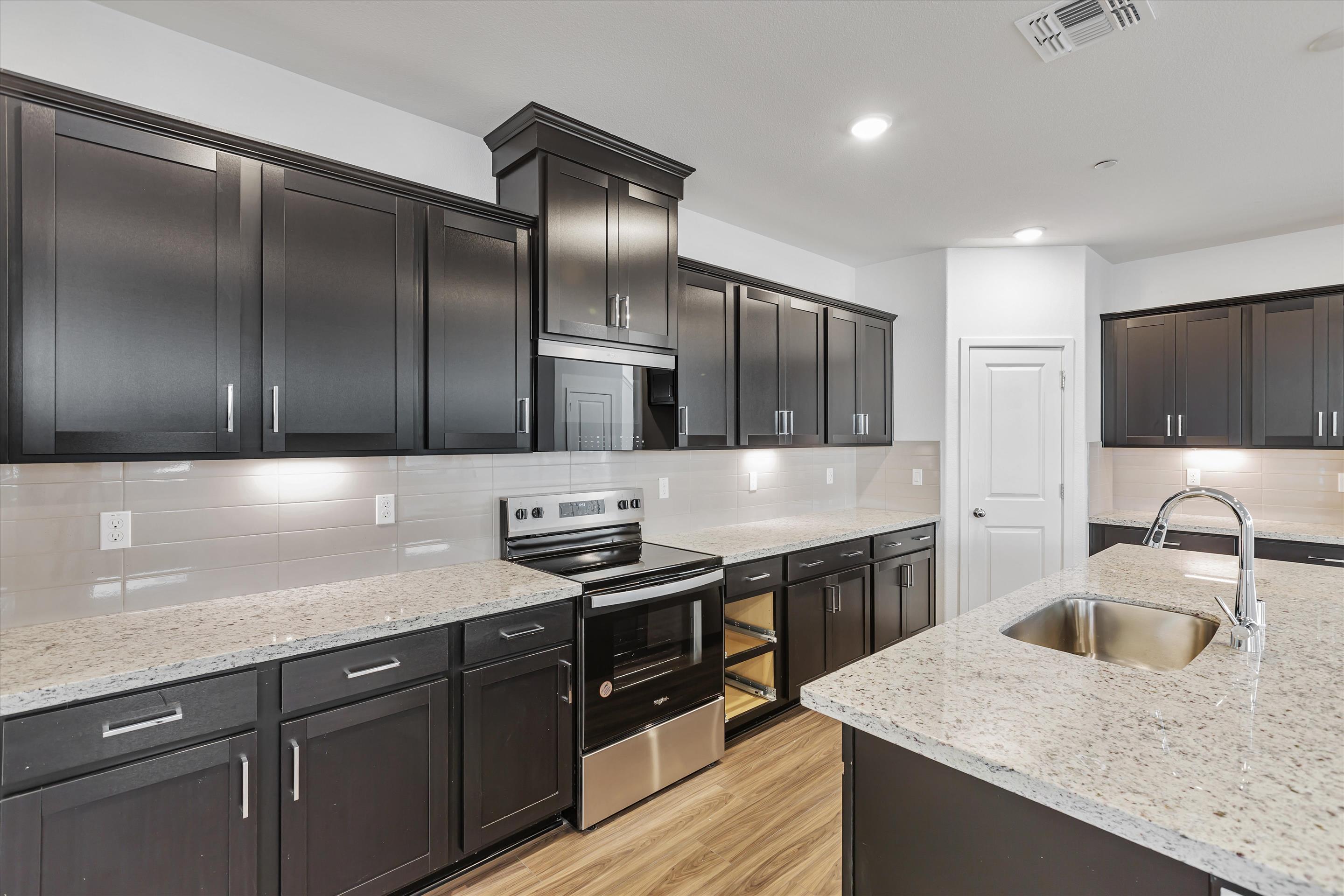 A kitchen with black cabinets.